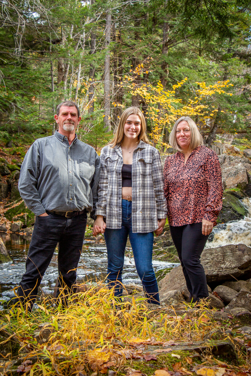 A photo from Jenna Longmire's Graduation session, shot in Acacia Valley Trail in Digby, with family members on a beautiful vibrant fall day